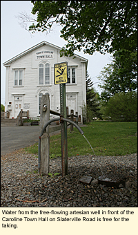 Water from the free-flowing artesian well in front of the Caroline Town Hall on Slaterville Road is free for the taking.