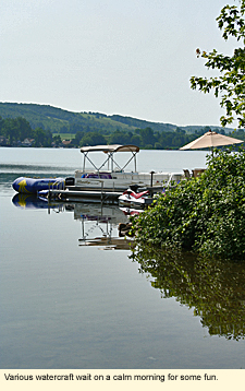 Various watercraft on Loon Lake in Wayland, New York wait on a calm morning from some fun.