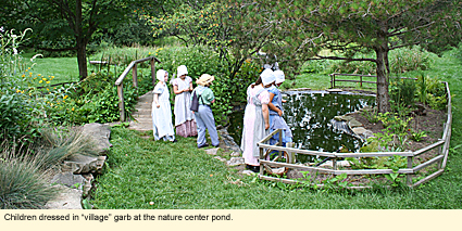 Children dressed in "village" garb at the nature center pond.
