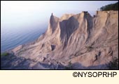 The sandy bluffs of Chimney Bluffs State Park loom over Lake Ontario in Wayne County in the Finger lakes Region, New York USA.