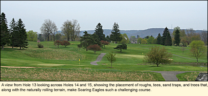 A view from Hole 13 of Soaring Eagles Golf Course, looking across Holes 14 and 15, showing the placement of roughs, tees, sand traps, and trees that, along with the naturally rolling terrain, make Soaring Eagles such a challenging course.