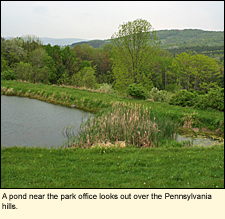 A pond near the park office looks out over the Pennsylvania hills at Two Rivers State Park in Waverly, New York, USA.