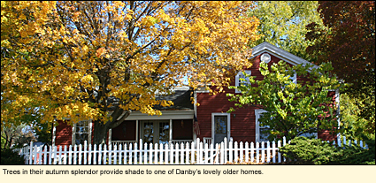 Trees in their autumn splendor provide shade to one of Danby's lovely older homes.