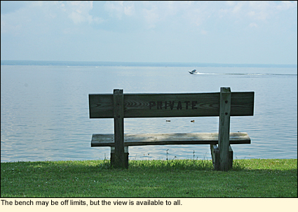 View of Oneida Lake in the Finger Lakes, New York USA from a wooden bench along the shore.
