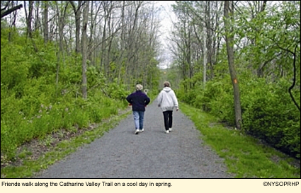 Friends walk along the Catharine Valley Trail on a cool day in spring in the Finger Lakes, New York, USA.