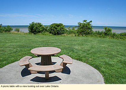 A picnic table a Chimney Bluffs State Park  with a view looking out over Lake Ontario.