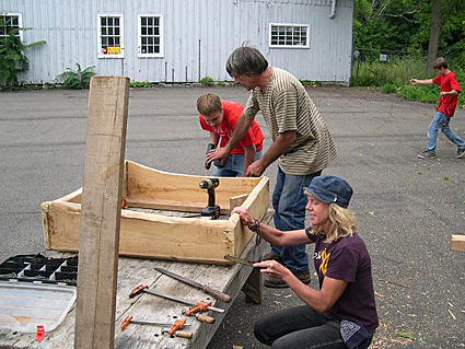 Photo 1-Dave Gell, executive director of Black Locust Initiative, with his assistant Melanie, and Zack of trumansburg/Ulysses Youth Services work on an osprey nest box made of black locust. Credit: Bill Evans  