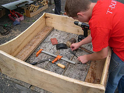 Photo 4-Zack, a member of Trumansburg/Ulysses Youth Services works on the osprey nest box to be installed at Treman Marina. Credit: Bill Evans