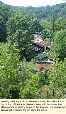 Looking into Stony Brook State Park from the east rim trail, Stony Brook is at the bottom of the frame, the bathhouse is in the center, the playground and parking lot are in the distance. The swimming area is out of view to the left along the brook.