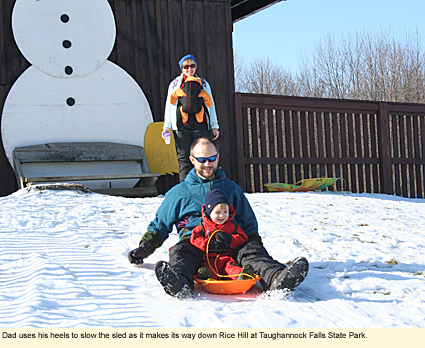 Dad uses his heels to slow the sled as it makes its way down Rice Hill at Taughannock Falls State Park.