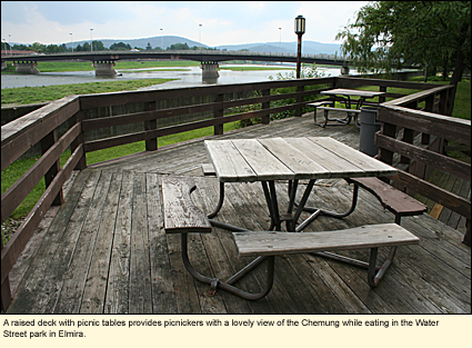 A raised deck with picnic tables provides picnickers with a lovely view of the Chemung River while eating in the Water Street park in Elmira.