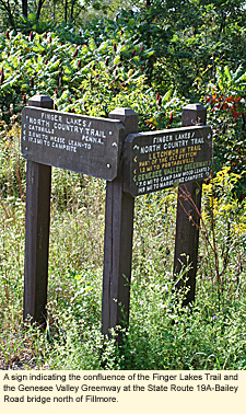 A sign indicating the confluence of the Finger Lakes Trail and the Genesee Valley Greenway at the State Route 19A-Bailey Road bridge north of Fillmore.
