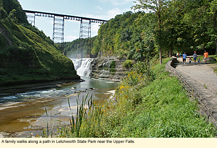 A family walks along a path in Letchworth State Park near the Upper Falls.