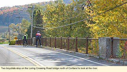 Two bicyclists stop on the Loring Crossing Road bridge north of Cortland to look at the river.